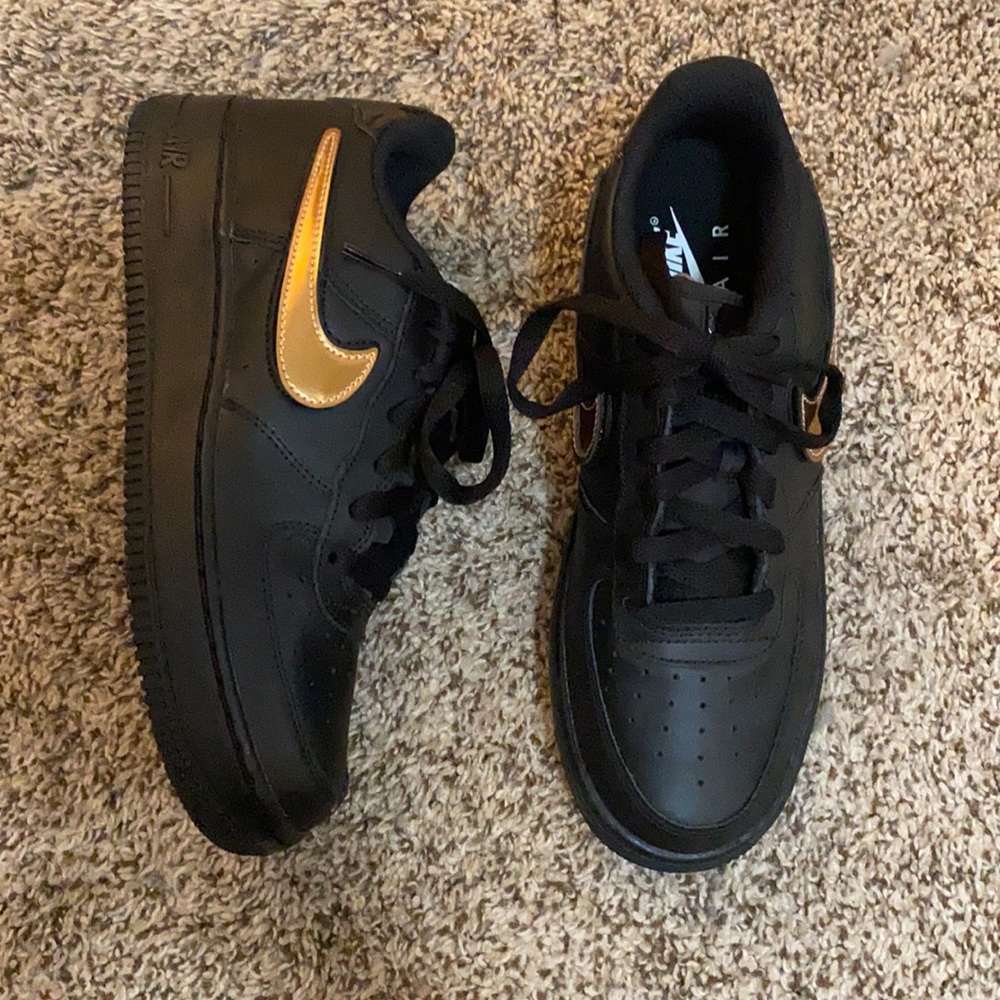 Custom Black Nike Air Forces with interchangeable chrome Nike symbols.